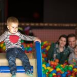 young parents with kids in a children's playroom