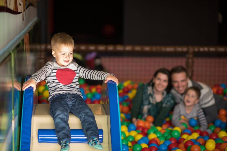 young parents with kids in a children's playroom